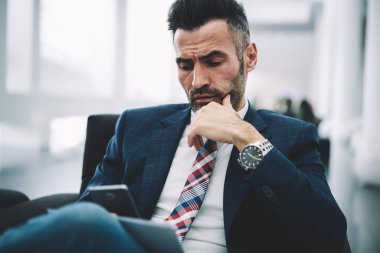 Şık elbiseli Smartphone cep telefonu ile 4 g internet bağlantısı üzerinden internet sitesinde son finansal haber okumak emin olgun iş adamı. Gurur CEO'su 50 yaşında cep bankacılığı hesabı kontrol deneyimli