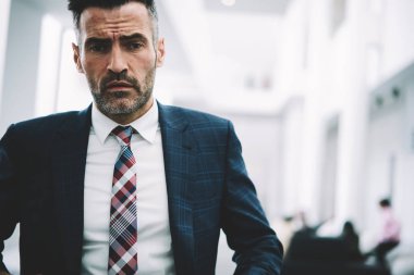 Yarım uzunluk portre emin gurur CEO 50 yaşında kameraya bakıyor. Başarılı olgun işadamı formal giyim ofis iç kapalı duran giyinmiş. Finans şirketinin erkek sahibi