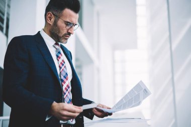 Dalgın girişimci 50 yaşında çalışma office metin belgelerinde finansal raporlar kontrol. Formal giyim muhasebe raporları bankacılık veri okuma konsantre olgun gurur CEO'su giymiş