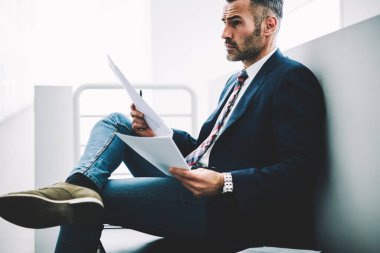 Girişimci 50 yaşındaki formal giyim ofis iç oturan kağıt mali belgelerin incelenmesi eski durulması. Muhasebe raporları holding ve düz seyir düşünceli olgun tüccar