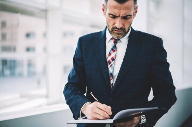 Not defteri daimi ofis iç yapım notları başarılı gurur CEO'su orta yaşlı. Kendine güvenen deneyimli olgun Finans Müdürü muhasebe belgeleri imzalama formal giyim giyinmiş