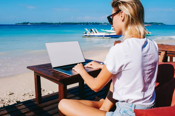 年轻的千禧时髦女孩键盘坐在海边的笔记本电脑上度假时 女性旅行博客在亚洲旅行期间远程工作 享受风景秀丽的海景 Typin — 图库照片