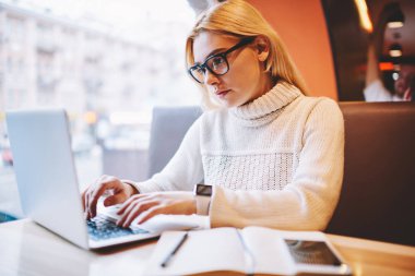 Gözlük vizyon koruma kafe Ardiles, dizüstü bilgisayar, öğrenme için ciddi hippi kız kız öğrenci autodidac üzerinde vakit netbook üzerinde çevrimiçi öğretici izlerken konsantre