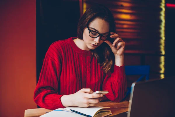 Doordachte Vrouwelijke Student Lezen Nieuw Bericht Smartphone Terwijl Het Leren — Stockfoto