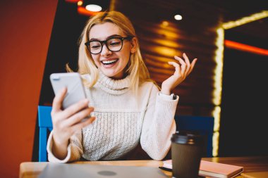 Neşeli hippi kız iyi haber posta Smartphone cep telefonu ile kahve dükkanı, duygusal kadın telefon haber kontrol Internet iletişim için indirim söyleyeceğiiçin çok mutlu oturma okuma ile heyecanlı