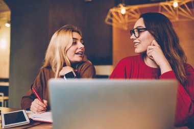 Kurs proje paylaşımı fikirleri birbirleri ile işbirliği sırasında en iyi arkadaşlar birlikte office sınav preparatio hakkında konuşurken coworking öğrenme iletişim hippi kız gülümseyerek