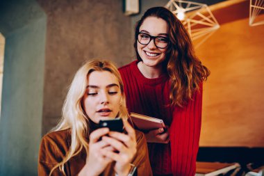 Smartphone, hippi kız colleagu ile iletişim görmezden cep üzerinden ağ üzerinde metin mesajları gönderme konsantre arkadaş ile vakit neşeli genç kadın portresi