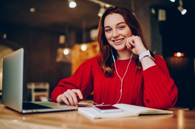 Akıllı telefon ve kulaklık, kız öğrenci technolog kullanarak alanı coworking eğitim ile memnun mutlu üzerinden dinleme kayıtları dil öğrenme zevk neşeli hippi kız portresi
