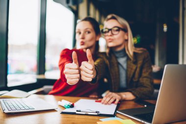 Kameraya bakarak iki başarılı kız öğrenci wich, üye seçici odak seviyor. Arka plan birlikte dizüstü bilgisayarda Üniversitesi'nde çalışan yukarı başparmak gösterilen mutlu arkadaşlarım ile bulanık