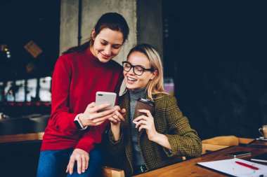 Komik yorum blog yolu ile 4 g takipçileri tartışırken neşeli arkadaşlarım internet Smartphone-e doğru bağlı. Pozitif öğrenciler üniversitede kahve molası sırasında Web sitesi mobil video izleme
