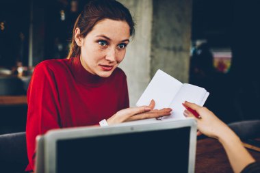 Genç kadın Not Defteri'nde ödev denetleme sırasında yazılı bilgilerle şaşırmış şaşkın. Defterini üzerinde işaret ve test kapalı coworking içinde oturan yapılan hata çözümleme kadın öğretmen merak ettim