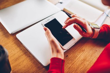 Kırpılmış görüntü ekranda yüksek hızlı internet bağlantısı üzerinden mobil uygulama yüklemek için modern smartphone yazarak kadın el. Sosyal ağlar üzerinde telefon ile paylaşım medya alanı alay