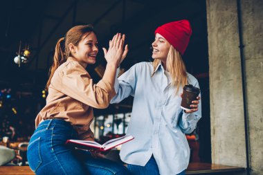 Beş birbirlerine eğitim üzerinde dostça işbirliği sırasında vererek mutlu hipster gençler uzay coworking oturan proje. Verimlilik takım çalışması hakkında olumlu genç kadınların baş