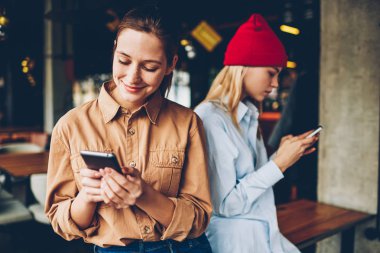 Neşeli iki hipster gençler Smartphone'da dostu toplantı sırasında canlı görüşme ihmal ederek sohbet online sosyal ağlardan bağımlısı. Antisosyal blogcular Online üzerinde hücresel mesajlaşma