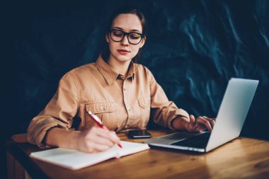 Dalgın akıllı hipster blogger bazı fikir dizüstü bilgisayar üzerinde kendi web sayfası geliştirmek için Not Defteri'nde belirterek bağlı kablosuz 4 g için Internet. Bilgi Web sitesinden yeniden öğrenci konsantre