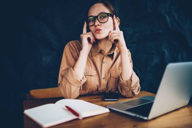 Portre pozitif genç kadının Eyewear laptop eğitim sırasında kameraya poz komik surat vizyon düzeltme için bağlı 4 g için Internet. Neşeli hipster blogger ile dudakları öpücük