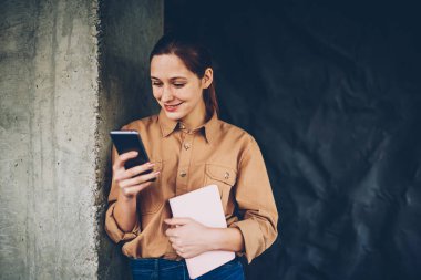 Smartphone aygıt profili güncelleştirmek için 4 g bağlıyken neşeli hipster blogger gülüyor Internet. Pozitif öğrenci ders kitabı elinde telefon sosyal ağlarda komik Haberler okuma ile