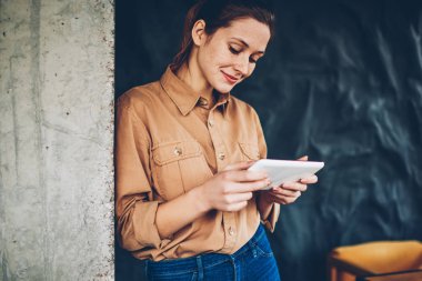 Pozitif kadın blogger ilginç eğitsel online web sitesi üzerinden yüksek hızlı izlemek için dijital tablet Internet bağlı. Hipster öğrenci sosyal ağlar modern dokunmatik yüzey üzerinde iyi haber okuma
