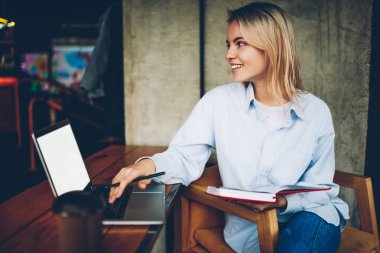 Dijital netbook aygıt uzaktan çalışma mutlu sarışın freelancer bağlı 4 g kablosuz internet. Pozitif hipster blogger ile mesafe işi sırasında dizüstü bilgisayar el gülüyor ders kitabı