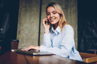 Başarılı kadın çevirmen kafe iç oturan boş zaman zaman içinde smartphone dostu mobil konuşma yaparken kameraya gülümseyen portresi. Pozitif hippi kız cep üzerinde arama