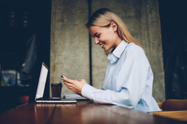 Mutlu hipster smartphone aygıt takipçileri ile blogger online sohbet yan görünümü bağlı 4 g ağlarda mesajlaşma space.positive öğrenci coworking içinde modern netbook oturan internet
