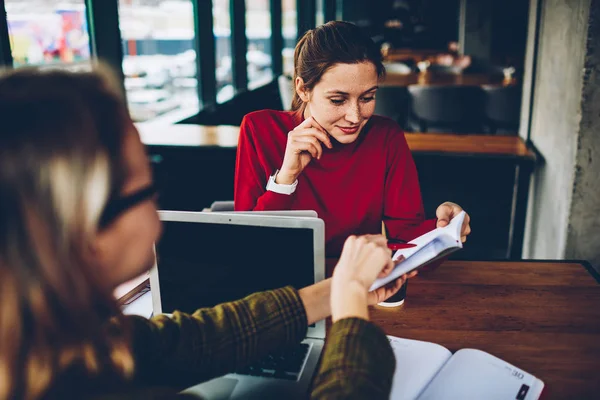 Dalgın güzel öğrenci kitap hangi kablosuz Internet bağlantısı eğitim alanı coworking ile modern netbooks, sınava hazırlık sırasında arkadaş tarafından gösterilen metin bilgileri okuma