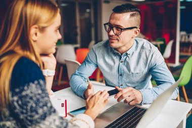 Genç erkek ve kadın iş arkadaşlarınızla işbirliği fikirler coworking uzayda birlikte teknoloji kullanarak ve kampüs bilgileri analiz sınavlarına hazırlık öğrencileri tartışırken başlangıçta zevk