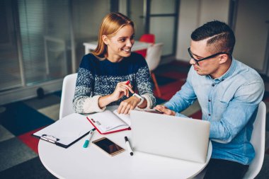 Genç öğrenciler fro kampüs içinde oturan birlikte iyi bir ruh hali içinde görev tamamlama sınavları hazırlık teknolojisini kullanarak Office işbirliği zevk proje hakkında konuşmayı olumlu iş arkadaşları