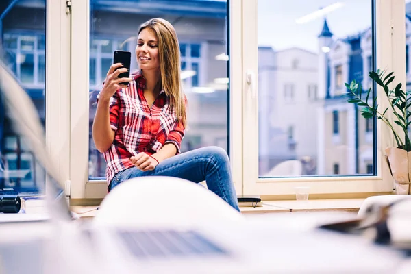 Okouzlující Mladá Žena Sedí Okenním Parapetu Smartphone Pro Pořizování Selfie — Stock fotografie