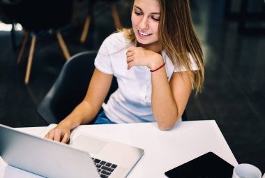 Kız öğrenci tarama eğitim web sitesi online kampus içinde dizüstü bilgisayar üzerinden öğrenmek için gülümseyen, işini geri bildirimler almak web sayfalarında içerik güncelleştirme başarılı kadın freelancer memnun
