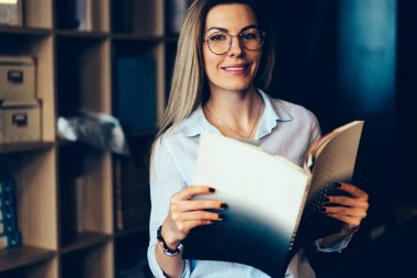 Yarım uzunluk portre çekici neşeli kadın Blogger gözlük gözleri koruma kapalı dinlenme zevk için. Kameraya Dergisi elele süre seyir muhteşem duygusal hippi kız