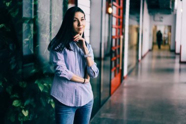 Pozitif düşünceli esmer kadın büyüleyici kapalı başarılı iş başlangıç hakkında rüya şık elbise giymiş. Modern ofis dururken durulması muhteşem düşünceli hippi kız