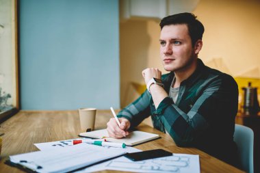 Not Defteri'nde, masaüstü Kırtasiye ve kağıtları ile oturma alanı coworking ödev proje yapıyor akıllı erkek öğrenci metin yazma makale oluşturma için fikir düşünüyorum yetenekli hipster adam