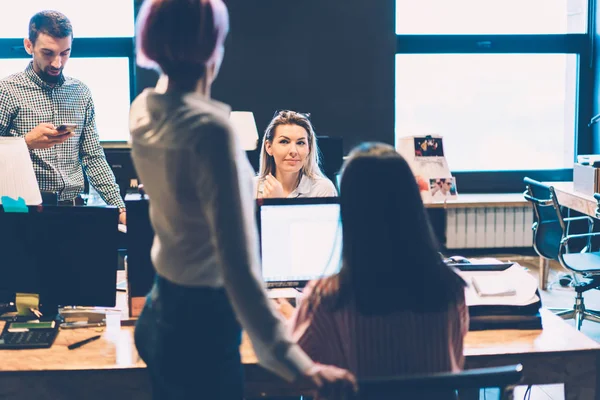年轻女子与同事一起讨论工作过程中坐电脑的计划 在时尚的办公室内部 在商业公司合作的男女员工共同创业项目 — 图库照片