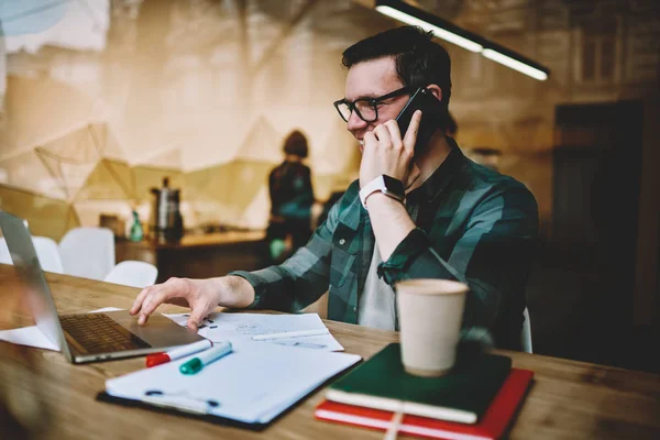 Freelancer Masculino Próspero Falando Telefone Enquanto Faz Trabalho Remoto Interior — Fotografia de Stock