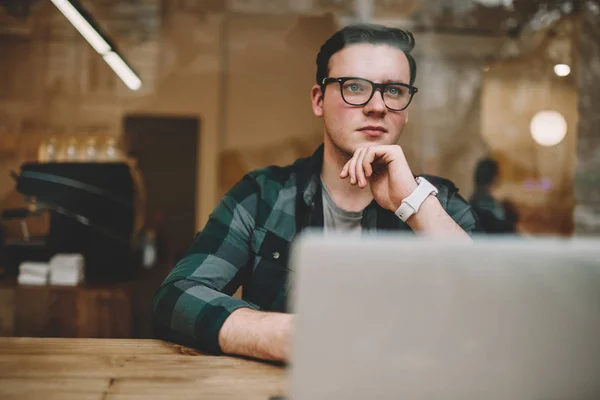 Allvarlig Manliga Frilansare Glasögon Begrunda Arbetsprocessen Bärbar Dator Café Inredning — Stockfoto