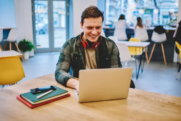 Fröhlicher Hipstertyp Mit Kopfhörern Der Computerspiele Genießt Freizeit Mit Laptop — Stockfoto