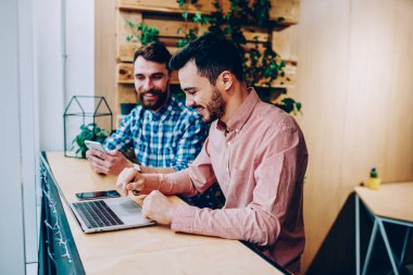 Öğrenme ve ödev college Kampüsü, içinde birlikte müreffeh erkek programları ile araçlar coworking'da oturan iş fikirleri tartışmak için modern dijital cihazlar kullanılarak hipster çocuklar gülümseyen