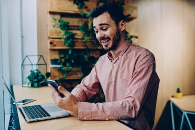 Akıllı telefon, sosyal ağ hücresel profildeki kampüs içinde dizüstü bilgisayar ile oturup komik fotoğraf gülüyorsun duygusal hipster adam üstünde posta okuma kısa mesaj ile sakallı adam hayret merak