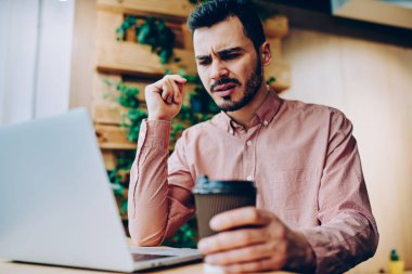 Uzaktan, kızgın genç erkek dizüstü ve üzgün faturaları internet bağlantısı kullanmak için almak posta kontrol çalışma netbook üzerinde dosyaları karşıdan yüklerken hipster adam yazılım hataları ile rahatsız vurguladı