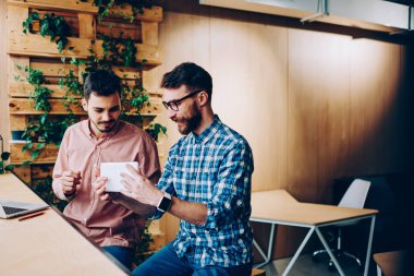 Genç hipsters yeni taşınabilir pc ve coworking içinde iletişim apps kontrol uzay mola verdim, yetenekli bu geliştiriciler memnun dijital tablet technolog için fikirler tartışırken yazılım güncelleştirme ile