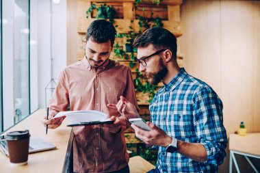 Profesyonel genç çalışanların ofis, yaratıcı çocuklar başlangıç strateji verimli iş bilgilerini kontrol için işbirliği söz coworking söz proje tamamlamak için planlama tartışıyor