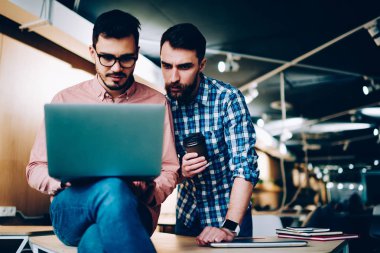 Dizüstü bilgisayar birlikte dizüstü bilgisayar, netbook işbirliği üzerinde web sayfasının güncelleştirmelerini okuma profesyonel çalışanlar seyir üzerinde uygulama hataları gidermek için ciddi erkek arkadaşları konsantre 