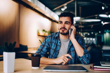 Genç hipster adam arkadaş ucuz cep telefonu tarifeleri kahve molası, üniversite cafeteri telefon görüşmesi sırasında boş zaman sahip yakışıklı erkek öğrenci üzerinde otururken kullanarak arama