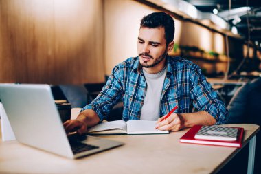 Erkek öğrenci Gözat bilgi office, Notepad için sosyal ağ yayın makale yazma dizüstü bilgisayar kullanan yenilikçi adam coworking içinde netbook üzerinde online kurslar ile dil eğitimi için