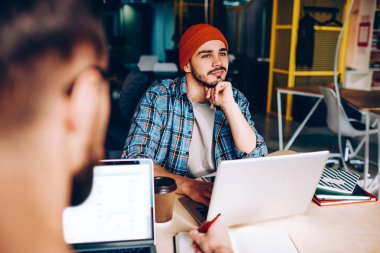 Şapkalı adam rüya gibi yenilikçi office programmin yılında meslektaşı ile otururken tatil hakkında düşünme düşünceli pozitif biri resim kırpılmış çalışma sürecinden dikkat dağıtıcı bir şey hayal