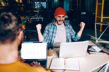 Dizüstü bilgisayar ekranı duygusal meslektaşım ise sahte ile zafer, hipster adam futbol maç translatio ile hayrete heyecanlı çığlık kaldırdı elleriyle çalışan erkek işçinin arkadan görünüm