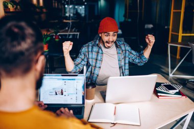 Çok memnun erkek futbol fan takım izlerken maç çığlık zaferi ile hayrete ve çalışma sürecinde duygusal hipster adam kazanma contes içinde harika bir haber kutlama eller yükselterek neşelen