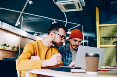 Yetenekli erkek bu geliştiriciler konsantre hipster çocuklar birlikte colleg eğitim web sitesinde izlerken webinar eğitim yazılım dizüstü bilgisayarda güncelleştirilirken işbirliği programlama