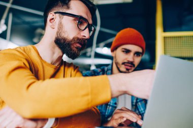 Yetenekli erkek görünümünü açıklayan, hipster adam arkadaş proje üzerinde birlikte gösteren yeni app netboo üzerinde çalışan ile iletişim sırasında dizüstü bilgisayarda işaret stajyer koçluk geliştirici kapatın